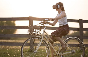 Meisje met VR headset op fiets