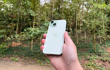 iPhone 15 review in groen in bos