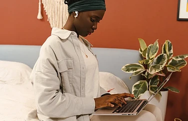 Vrouw met AirPods en MacBook