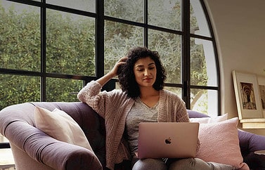 Vrouw op bank met MacBook gebruikt personal hotspot