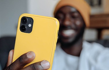 Man met iPhone in geel hoesje