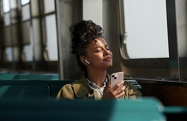 Vrouw met AirPods en iPhone 13.