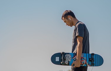 Man met AirPods en skateboard