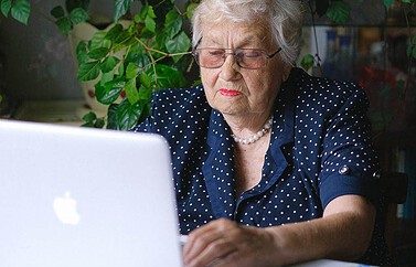 Oudere vrouw met MacBook