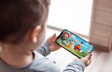 Kind met Angry Birds spelletje op iPhone
