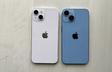 iPhone 13 in roze naast de iPhone 14 in blauw