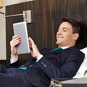Successful business man working with tablet PC in his hotel room (c) Robert Kneschke/Shutterstock
