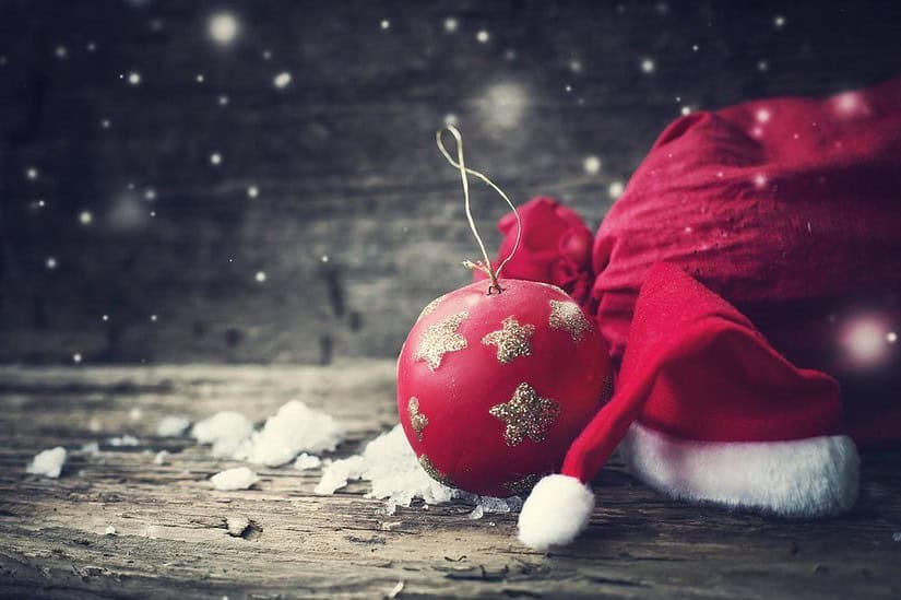 Kerstfoto via Shutterstock.com (http://www.shutterstock.com/pic-318588413/stock-photo-christmas-background-with-christmas-ball-gift-red-hat-and-snow-on-a-wooden-background-christmas.html), iravgustin
