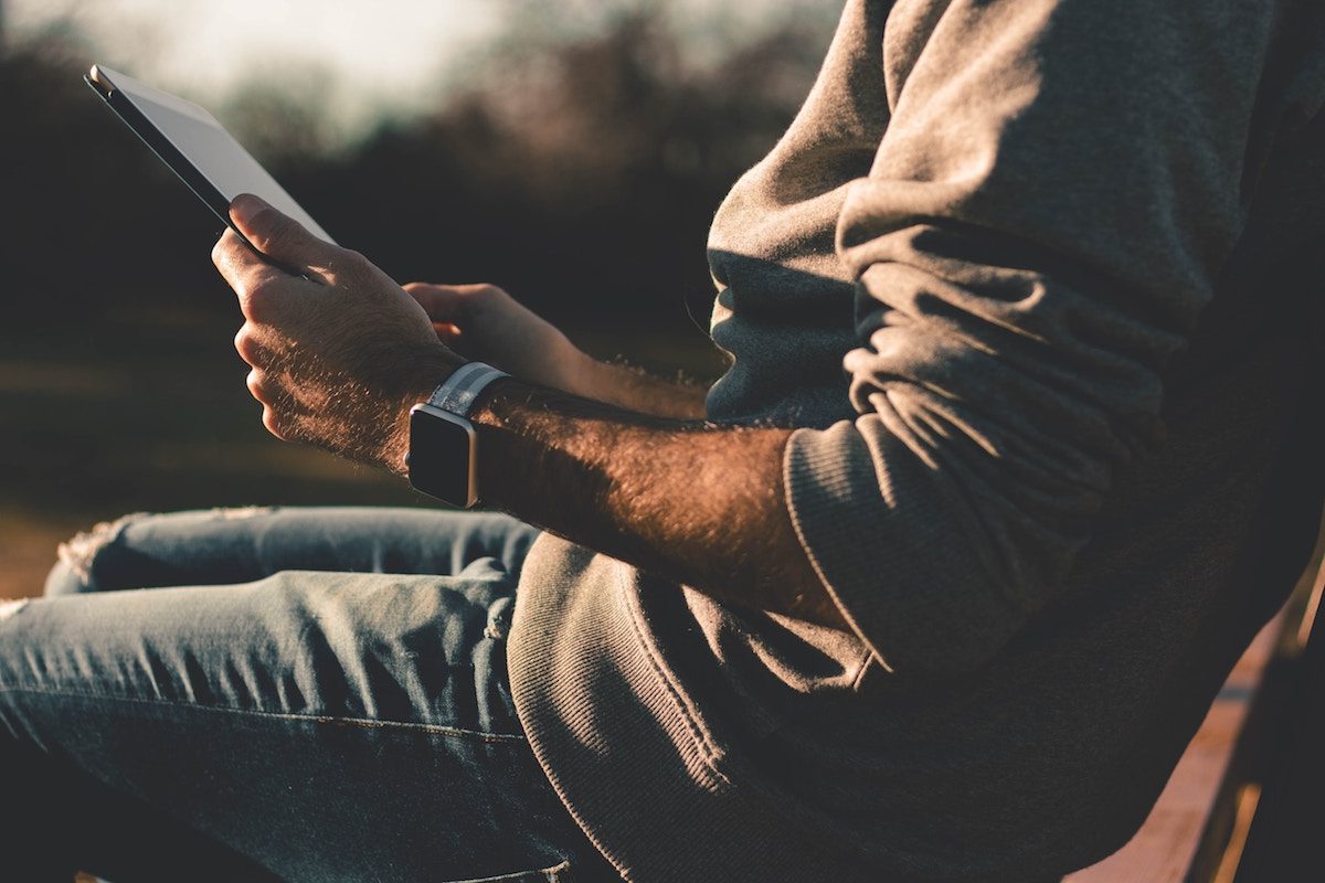 Man met iPad en Apple Watch