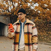 Man met iPhone in oranje hoesje