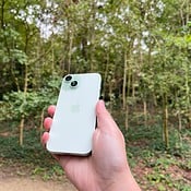 iPhone 15 review in groen in bos