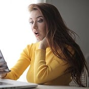 Vrouw met MacBook en iPhone, thuiswerken