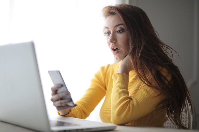 Vrouw met MacBook en iPhone, thuiswerken