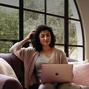 Vrouw op bank met MacBook gebruikt personal hotspot