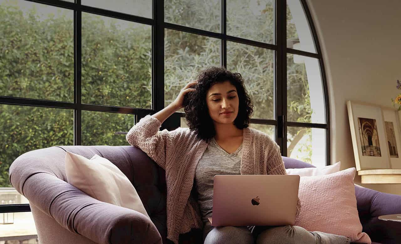 Vrouw op bank met MacBook gebruikt personal hotspot