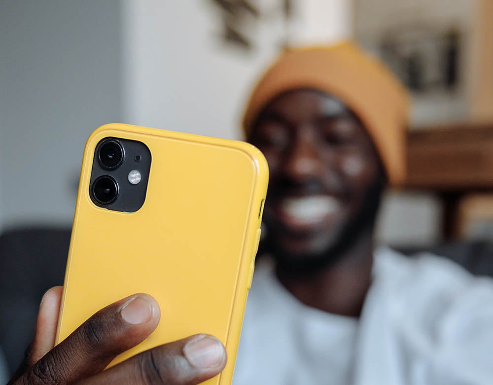 Man met iPhone in geel hoesje