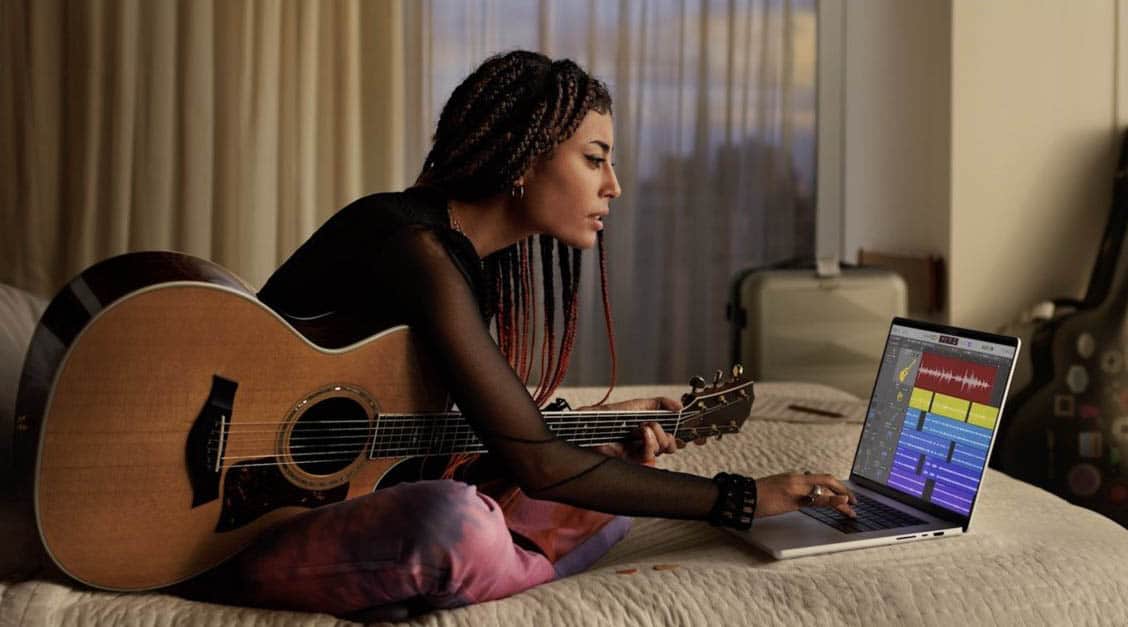 Vrouw met 2021 MacBook Pro in hotelkamer met gitaar