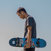 Man met AirPods en skateboard