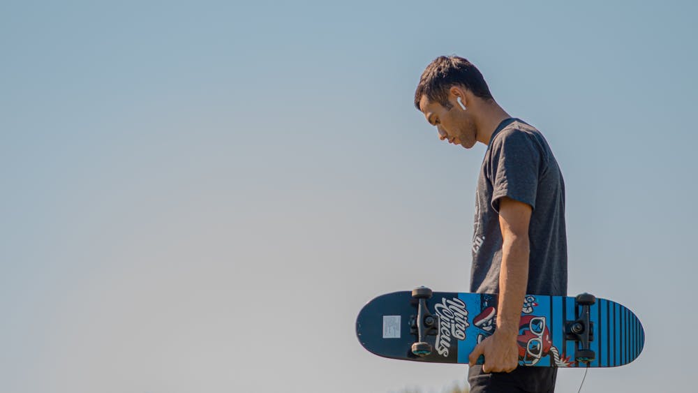 Man met AirPods en skateboard