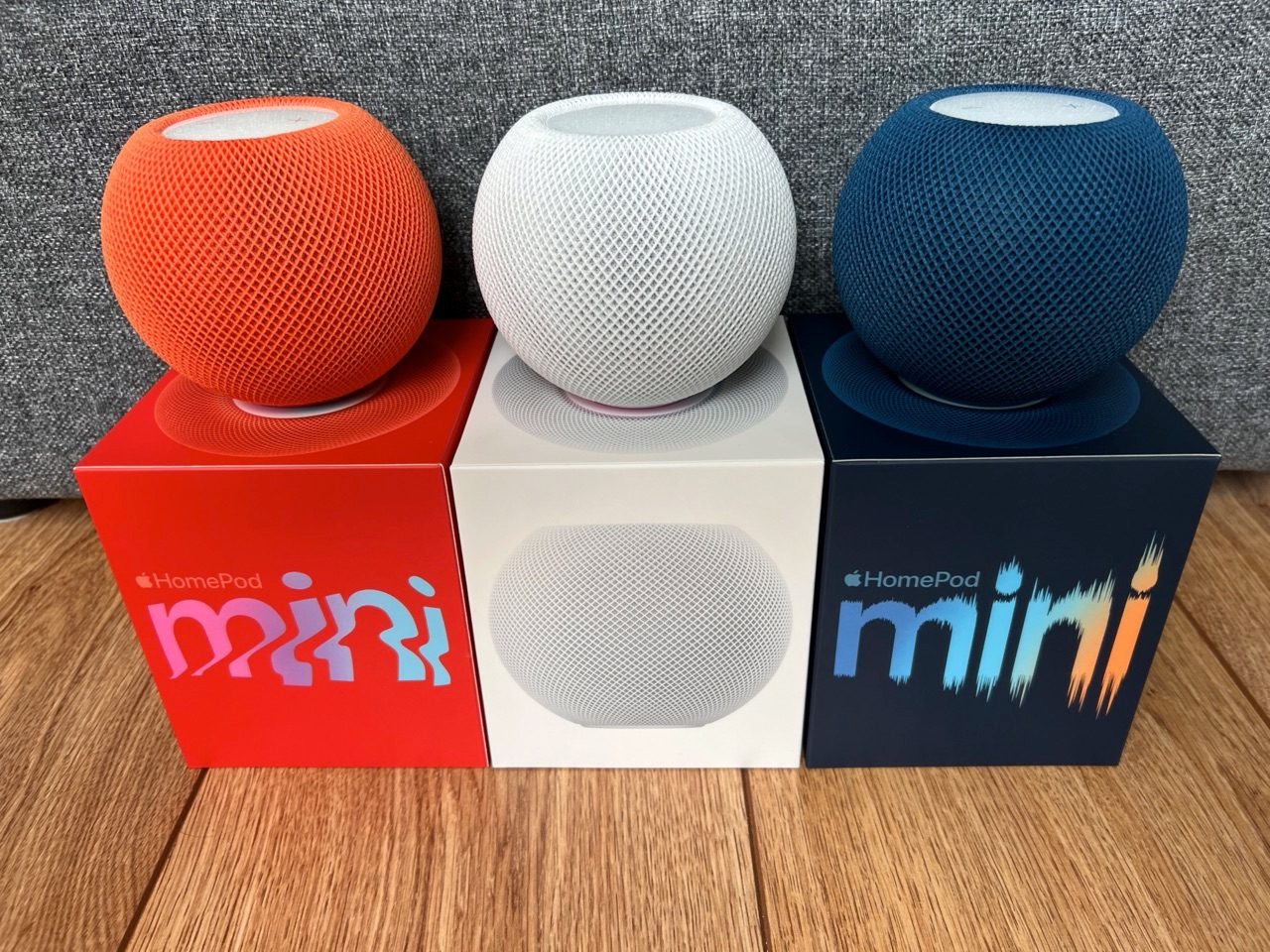 HomePod mini review in oranje, wit en blauw met dozen.