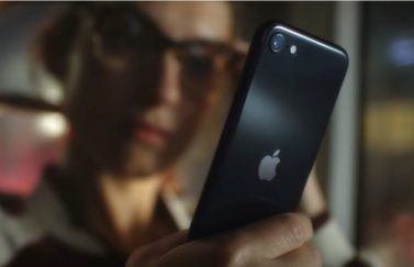 Vrouw met iPhone SE 2022 vanaf achterkant.