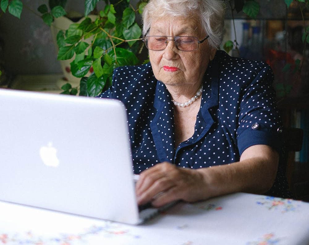 Oudere vrouw met MacBook