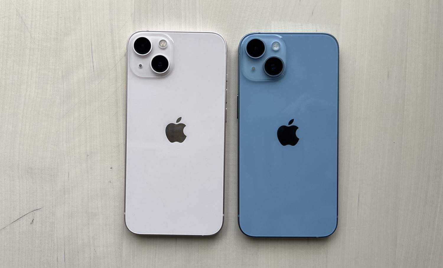 iPhone 13 in roze naast de iPhone 14 in blauw